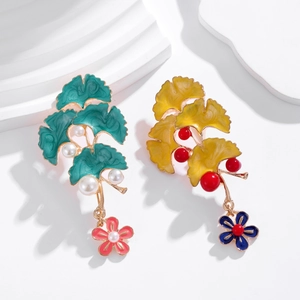 Detail of sweet ginkgo leaf brooch with green enamel coating and small white pearls