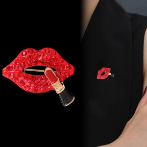 Broche rouge strass en forme de lèvres et rouge à lèvres sur un blazer noir