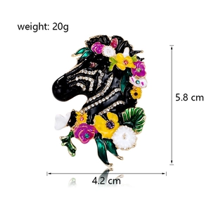 Spilla a testa di zebra in smalto con fiori colorati e strass su sfondo bianco