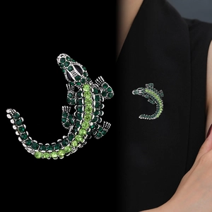 Vintage crocodile brooch with sparkling green rhinestones pinned to a black suit lapel