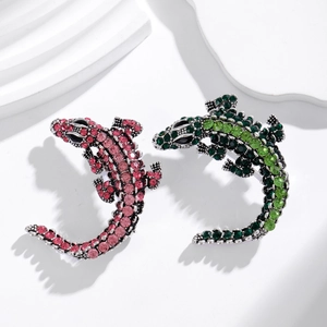 Detailed macro view of crystal-encrusted crocodile brooches in pink and green gradients