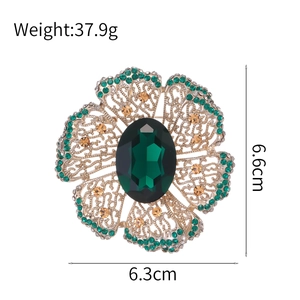 Vintage green crystal flower brooch with gold hollow petals and emerald gemstones