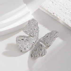 Detailed view of silver butterfly brooch with unique hammered metal texture and 3D wings