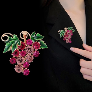 Broche raisin élégante avec cristaux roses et feuilles vertes sur un veston noir chic