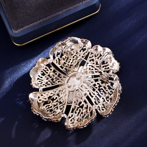 Vintage green floral crystal brooch with detailed hollow metal back and secure pin