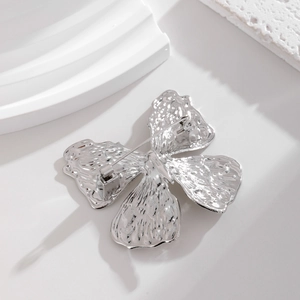 Detail view of silver butterfly brooch back showing pin mechanism and hammer texture finish