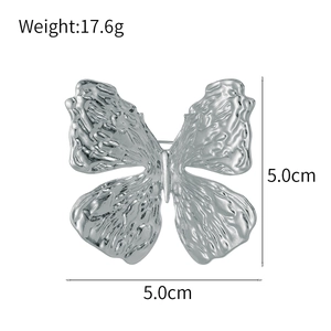Macro detail of silver butterfly brooch with hammered texture finish and 5.0cm dimensions