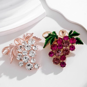 Détail de broches raisins en or rose avec cristaux et or avec des pierres violettes