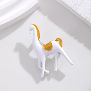 Vue détaillée d'une broche cheval blanc mat aux accents dorés sur support artistique