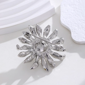 Broche tournesol argentée exquise avec perles et strass présentée de vue arrière