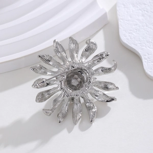 Broche tournesol argentée avec strass et détails de texture métallique au dos du bijou