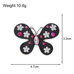 Exquisite butterfly brooch with black alloy base, white enamel flowers and pink crystals