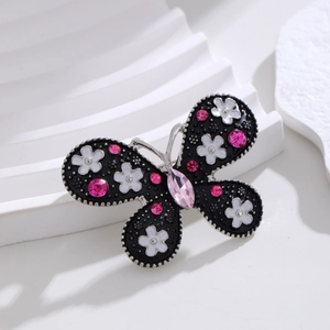 Exquisite butterfly brooch with black wings, pink crystals, and white enamel floral details