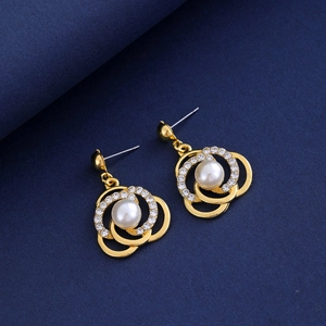 Vue détaillée de boucles d'oreilles dorées à trois anneaux avec perle et cristaux