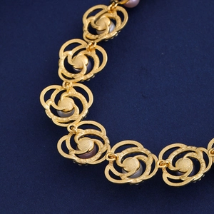 Collier rose doré ajouré avec incrustation de perles sur fond bleu foncé élégant