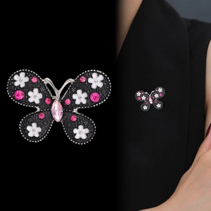 Elegant butterfly enamel brooch with pink crystals on a black suit lapel view