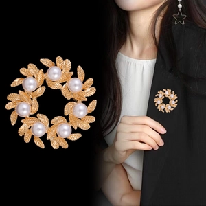 Detailed close-up and model shot of a matte gold wreath brooch with faux pearls