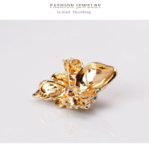 Detailed back view of golden butterfly brooch showing the secure pin clasp and metal texture