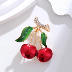 Broche cerise élégante avec émail rouge et feuilles de cristal sur présentoir