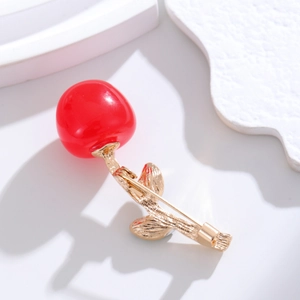 Elegant red cherry brooch for women featuring golden leaves on a minimalist white backdrop