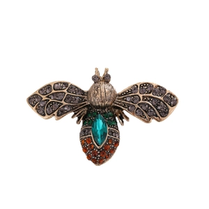 Vintage gold bee brooch featuring emerald green crystals and orange rhinestones on wings