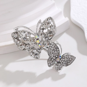 Macro shot of double rhinestone butterfly brooches with silver finish and crystal details