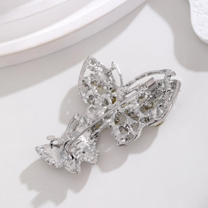 Silver butterfly brooch with rhinestones showing back pin closure on white background