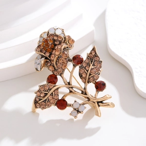 Close-up of vintage rose brooch featuring champagne rhinestones and opal-like stones