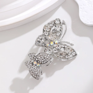 Detail of silver double butterfly brooch with sparkling crystals and rainbow rhinestones