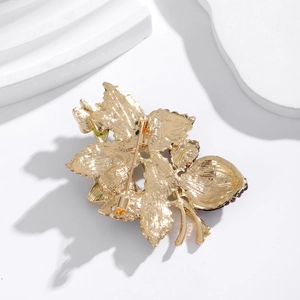 Detailed back view of the golden alloy strawberry brooch showing the secure safety pin clasp
