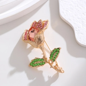Macro shot of rose flower brooch with pink diamonds and a pear-shaped orange crystal
