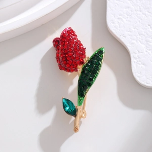 Close-up of elegant tulip brooch with red rhinestones and green enamel on gold finish
