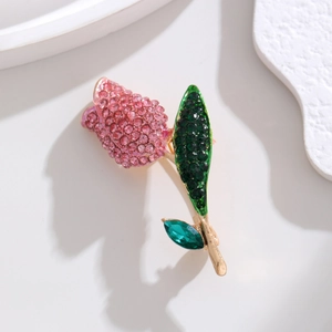 Macro shot of tulip brooch with pink and green rhinestones on golden alloy base