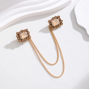 Close-up of vintage baroque double brooch with champagne crystals and gold chains