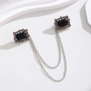 Detailed macro view of baroque vintage double-headed chain brooch with black stones