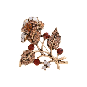 Vintage rose flower brooch with amber crystals and gold alloy base on white background