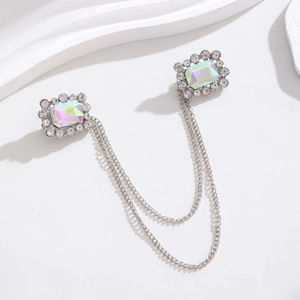 Detailed macro of vintage silver rhinestone brooch with iridescent crystal and dual chains