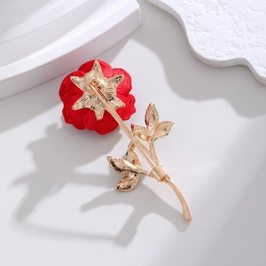 Detail view of the pin closure on a red rose brooch with golden stem and enamel leaves