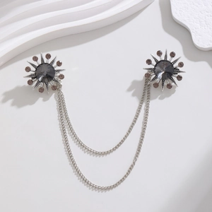 Detail of vintage sunburst brooch with large grey crystal and double chains for suits