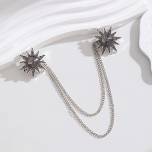 Macro detail of vintage silver star brooch with grey crystal and hanging chains