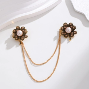Detail of vintage gold clover brooch with pink rhinestones and pearls on double chains