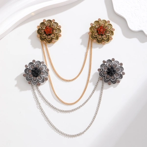 Close-up of vintage flower collar pins with dual chains and faux gemstones in gold and silver