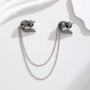 Detail of vintage fox collar pin with double chains, grey crystals, and silver texture