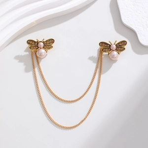 Détail de broches abeilles vintage avec strass et perles roses reliées par des chaînes d'or