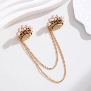 Vue détaillée de broches couronnes vintage avec perles roses et chaînes dorées