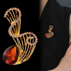 Elegante spilla dorata con grande cristallo rosso e strass su un abito nero