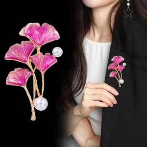 Broche feuille de ginkgo en émail rose avec perles sur un costume blazer noir