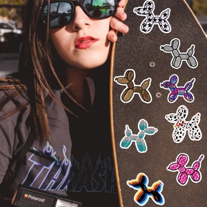 Close-up of diverse rainbow balloon dog stickers on a skateboard for custom decoration