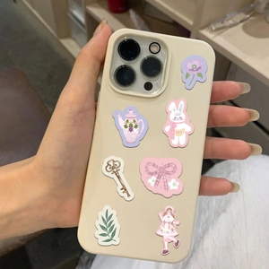 Close-up of cute girl stickers and Lolita style illustrations on a cream iPhone case