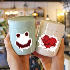 Close-up of horror-themed storage jars featuring red bloody smiley and heart patterns